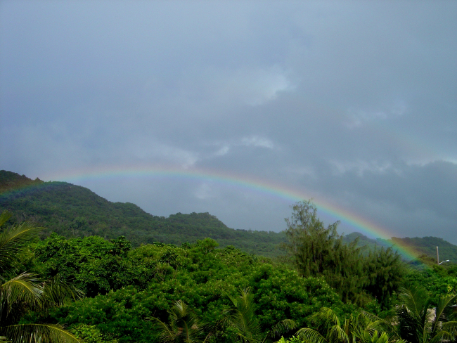 A rainbow graces the jungle foliage of the Guam mountains