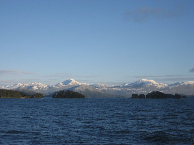 Mountains, islets, and snow along the Inside Passage