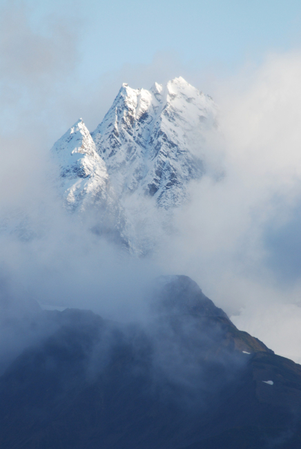 A magnificent mountain peak peeking through the clouds