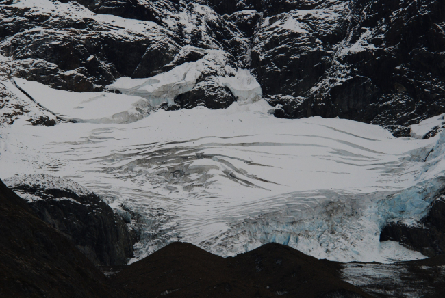 Crevasses and what appears to be a collapse feature in the center of a glacierlocated in the Johns Hopkins Inlet area