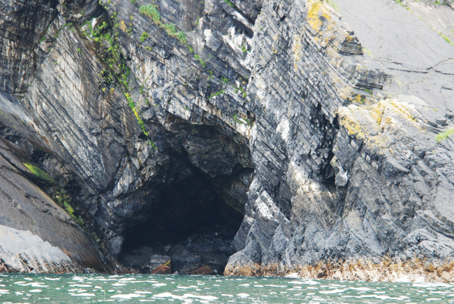 Tilted sedimentary beds and a large sea cave