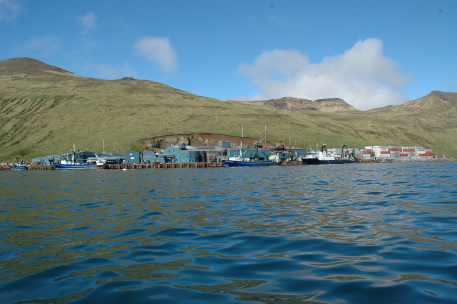 Fishing boats and stacked containers at Akutan Harbor