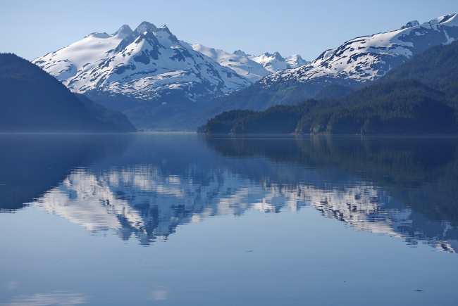 A placid view in Tutka Bay with near mirror-like conditions reflecting grandmountain scenery off the waters