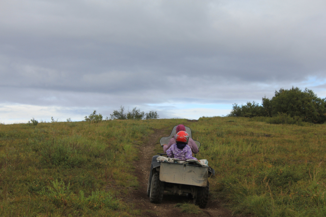 Mother and daughter going to harvest blueberries on the family ATV