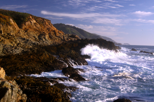 A wave breaking against the rocks of the Granite Canyon area along the Big Surcoastline
