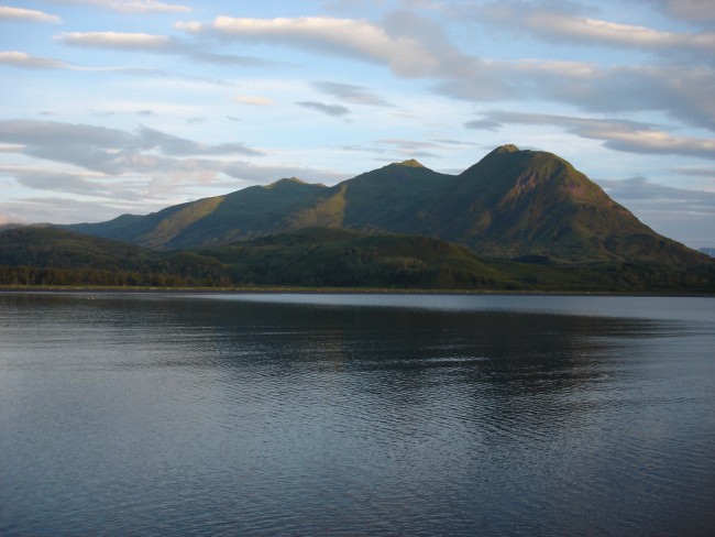 Mountains rise above a quiet Kodiak Island cove at the end of the day