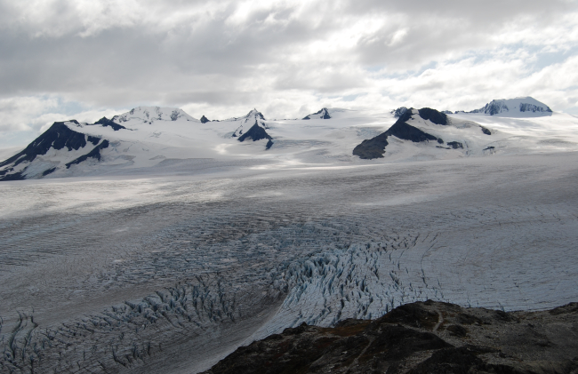 Highly crevassed glacier and surrounding mountain peaks