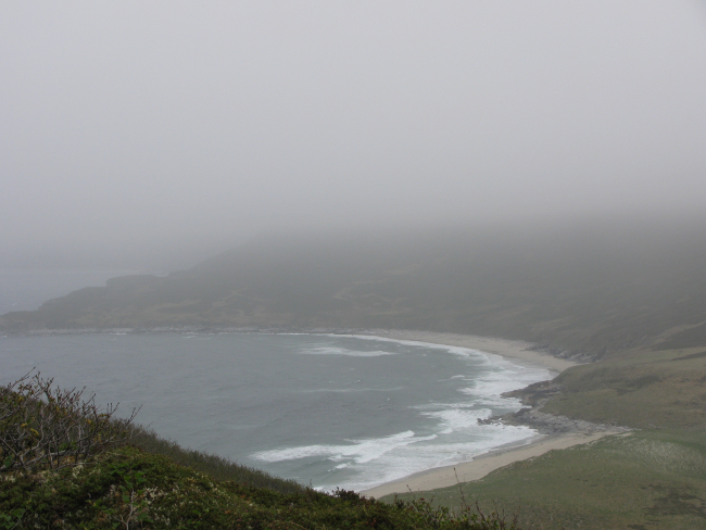 Moderate surf inside a fog-shrouded cove on Little Koniuji Island