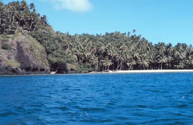 Coralline beach on volcanic island with fringing reef