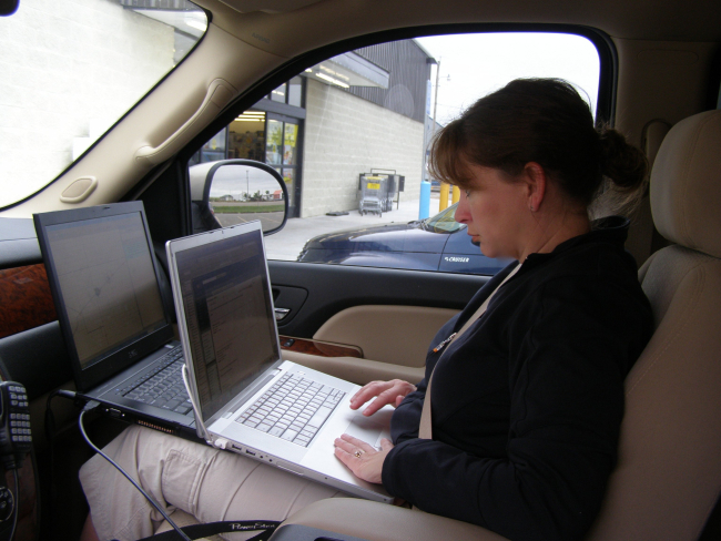 NSSL's Susan Cobb works on two laptops to upload video to a network TV station