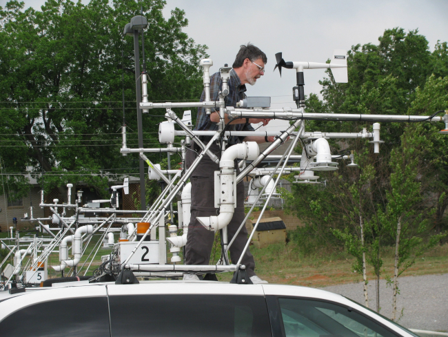 Sherman Frederickson, NSSL, woring on the instrument rack on top of a mobilemesonet vehicle