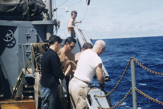 Fisheries scientist Townsend Cromwell standing above and behind scientistswhile launching scientific gear