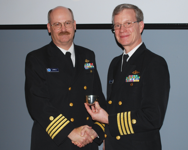 Captain John Lowell on left shaking hands with Captain Steve Barnum, retiringDirector of NOAA's Office of Coast Survey