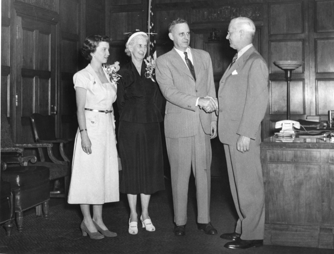 Daughter and wife of Rear Admiral Robert Knox who is being congratulated bySecretary of Commerce Charles Sawyer who is on the right