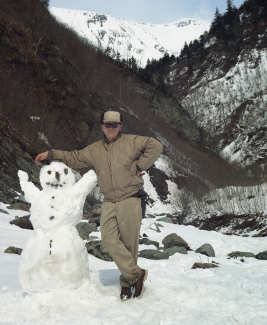Electronics technician Dan Twohig posing by Alaska snowman