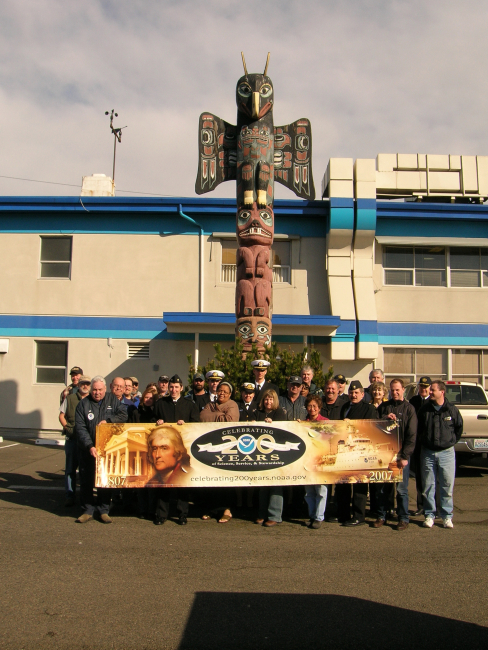 Personnel of the OMAO Marine Operations Center-Pacific proudly display theNOAA 200th Banner outside the headquarters building of the Marine Center