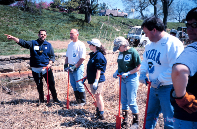 Glenn Page instructing volunteers in the art of wetland planting techniques atFt