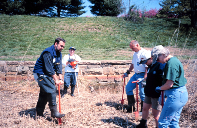 Glenn Page instructs volunteers in planting techniques