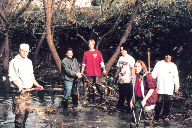 Student volunteers clear debris from the river