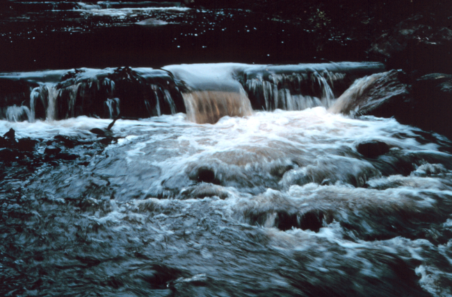 Water rushes over the lip of the pools
