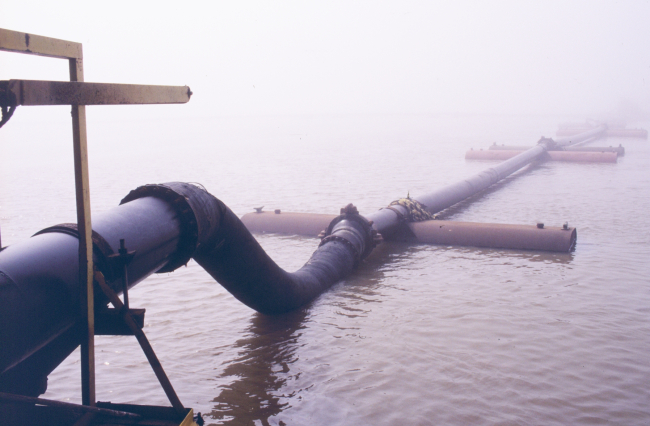 Dredged sediments being pumped through a pipeline toward the marsh creationdisposal area