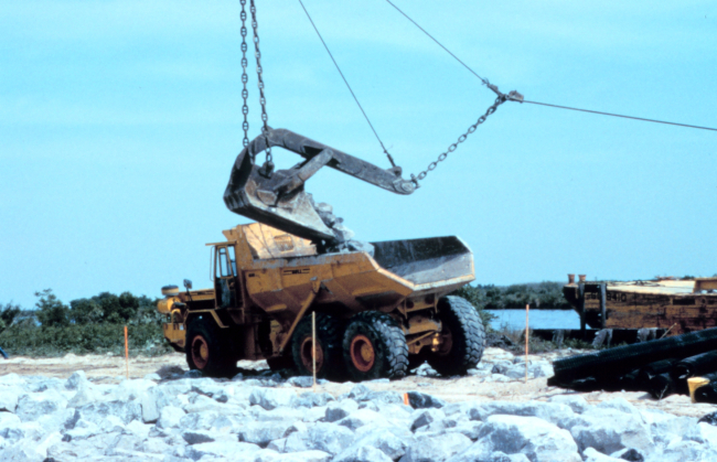 Another view of the crane loading rock into the truck