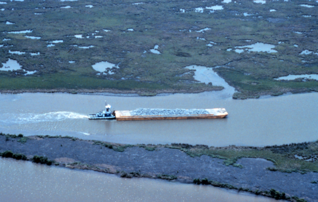 An aerial view of the tug loaded with rock traveling up Locust Bayou
