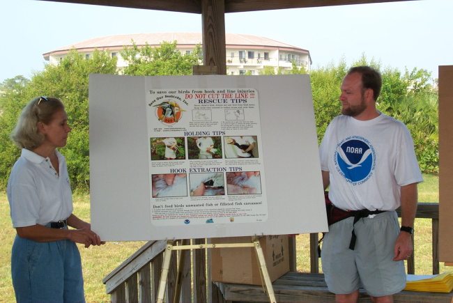 NOAA's John Iliff and a bird rehabilitator, Lee Fox, introduce a postercreated to educate volunteers about how to rescue injured birds