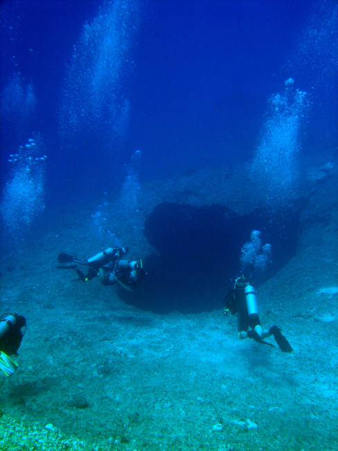 SCUBA divers approaching a sinkhole on a Guamanian reef