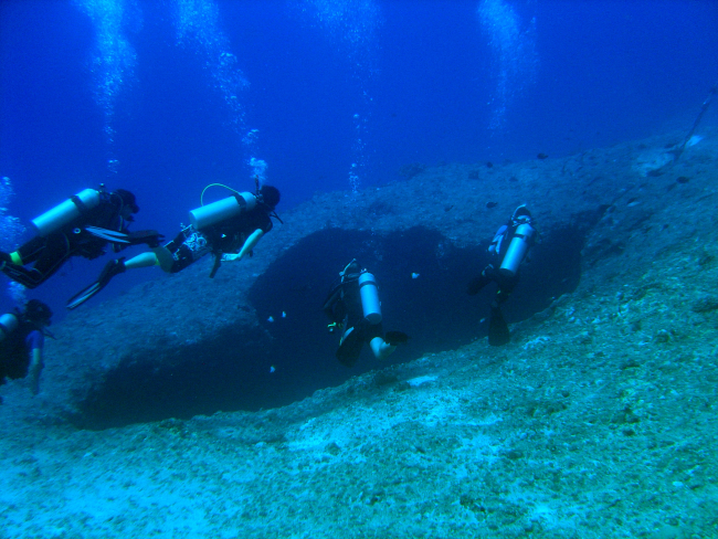 SCUBA divers approaching a sinkhole on a Guamanian reef