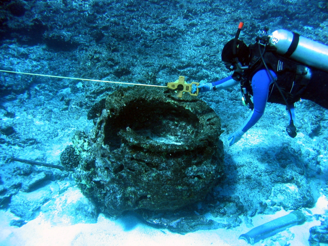 Measuring the distance from the blubber rendering pot to other debris of anearly Nineteenth Century ship wreck of a whaling vessel on Pearl and Hermes Reef