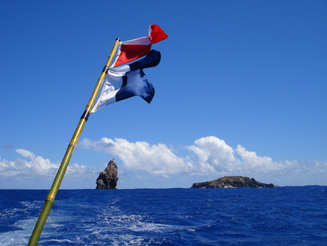 Flags denoting divers down with the islets of Motu Iti and Motu Nui in thebackground