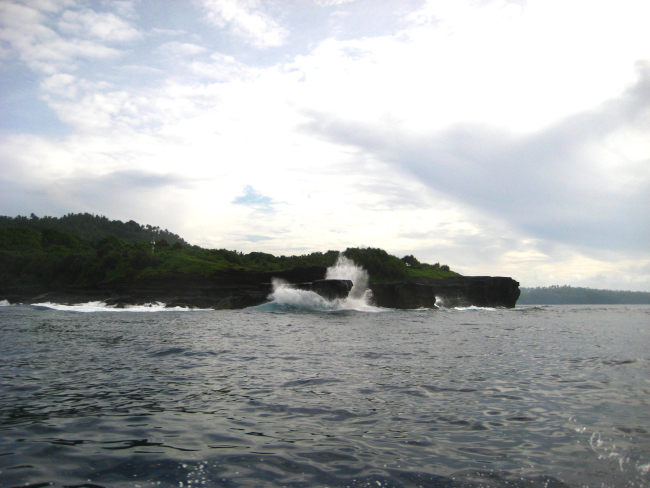 Large swells striking a rocky headland