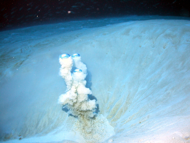 Bubbles of methane gas pushing up sediment from the crater of a mudvolcano