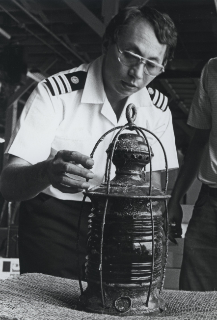 Commander Phil Johnson inspecting lantern recovered from the MONITOR