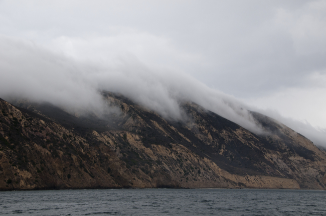 Fog streaming over Santa Cruz Island following stream valleys towards the sea