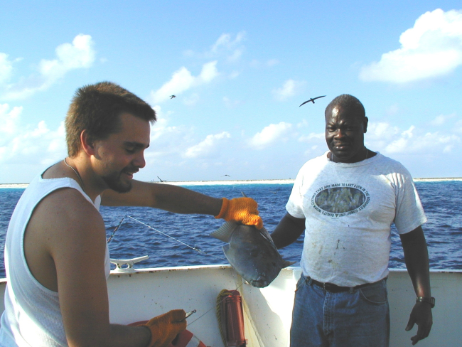 Deck hand Mike Theberge and seaman surveyor Leroy Johnson with fishcaught off Clipperton Island during STAR 2000