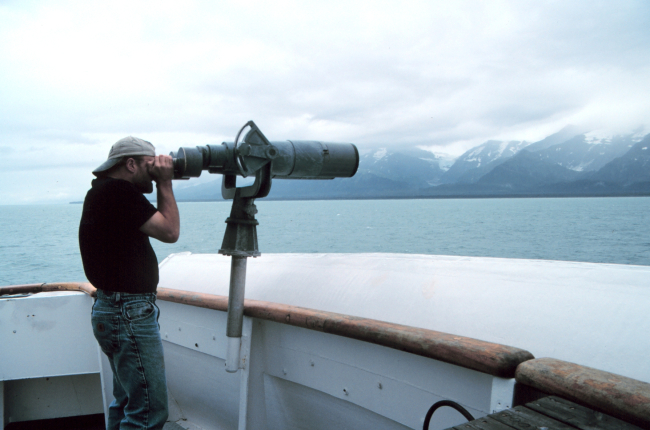 Marine mammal observer looking through the big eyes at Icy Bay
