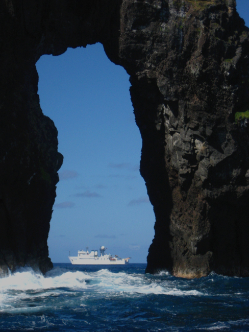 NOAA Ship HI'IALAKAI seen offshore through natural arch at Pagan Island