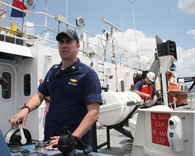 Lieutenant Commander Ben Evans operates propulsion controls on the portbridge wind of the NOAA Ship FERDINAND R