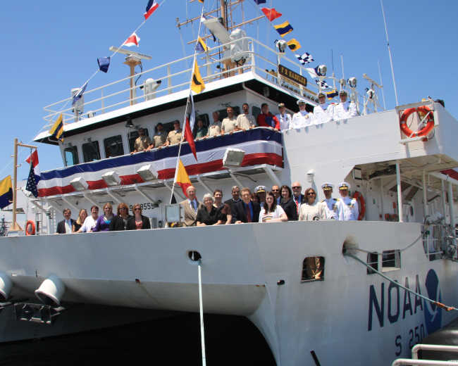 Dignitaries and guests line the railing of the NOAA Ship FERDINAND R