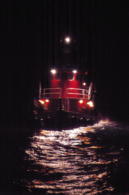 Tug boat on stormy seas at an oil platform site