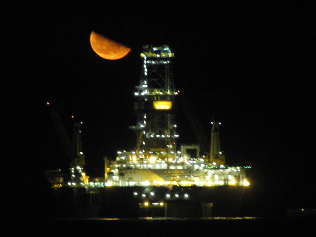 A view of a Deepwater Horizon disaster relief drill vessel with a half moonrising? setting?