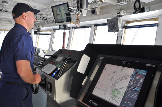 Ensign Pfundt at the helm off Cape Prince of Wales on the NOAA Ship FAIRWEATHER