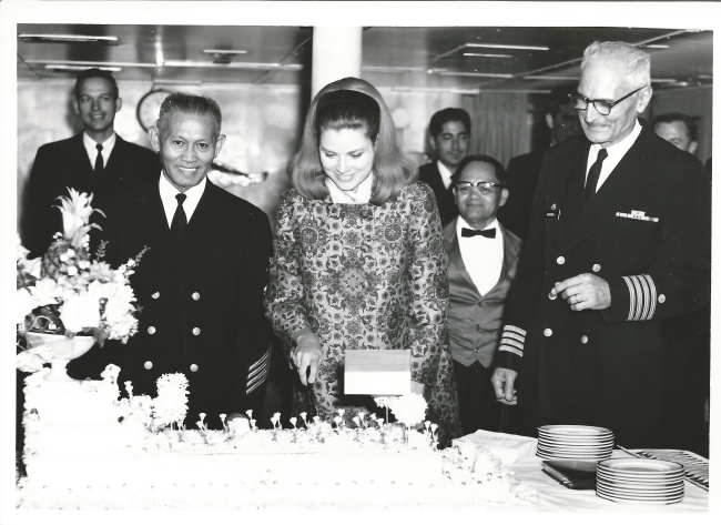 Captain Arthur Wardwell, Princess Grace of Monaco, and Chief Steward Joe Daceracutting a celebratory cake