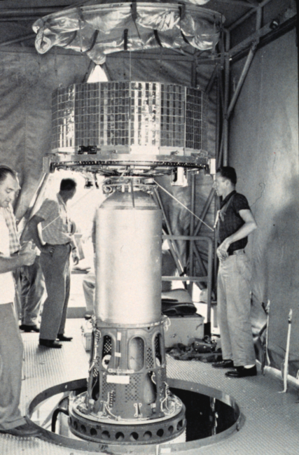 Mounting early TIROS satellite on nose of rocket prior to launch