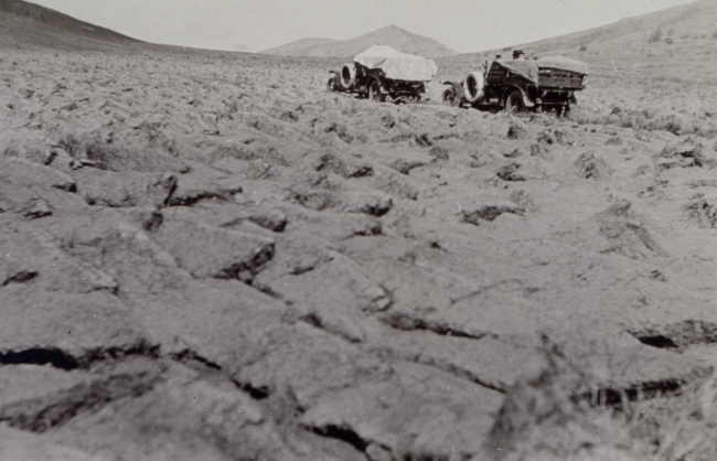 Trail through plowed field - White 3/4 ton truck