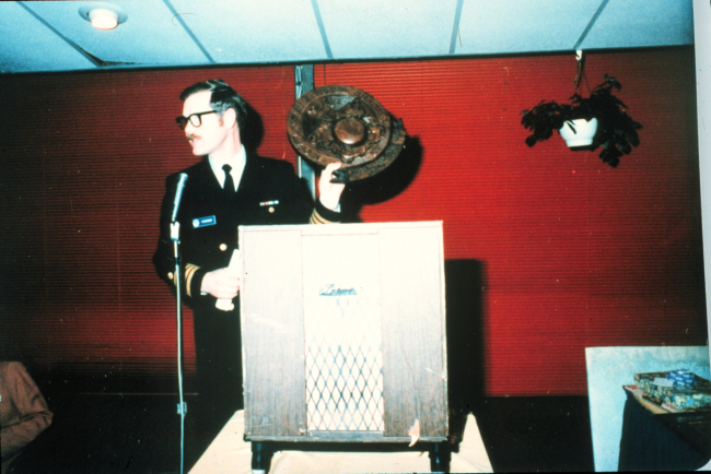 Captain Sig Peterson preparing to make presentation of carved NOAA Corpsplaque to Rear Admiral Harley Nygren (out of picture)