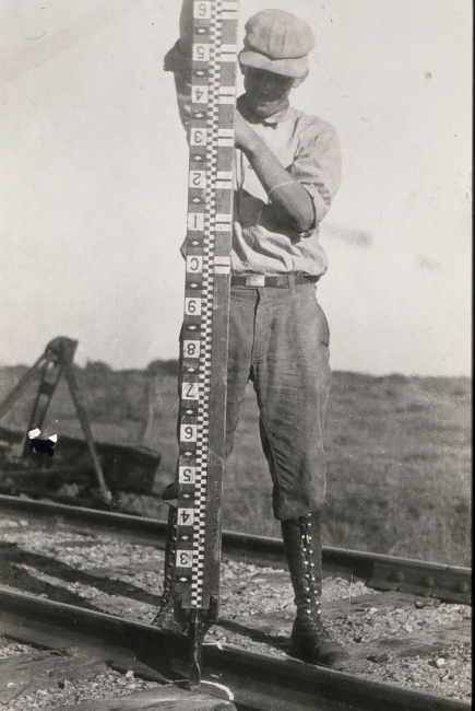 Rodman holding rod vertical during observations