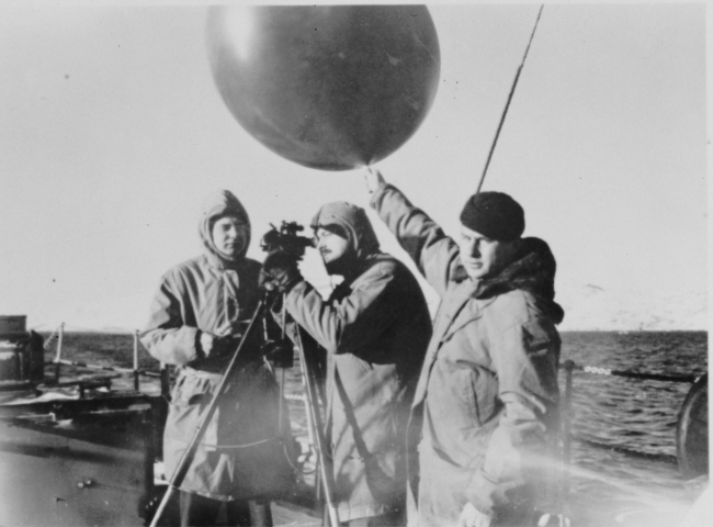 Launching and preparing to track a pilot balloon from a Coast Guard vessel